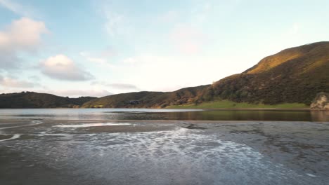 Luftumlaufbahn-Von-Drohnenflugzeugen,-Die-Am-Strand-Saugen,-Houhora-Köpfe,-Küstenlandschaft-Von-Neuseeland-Im-Hintergrund