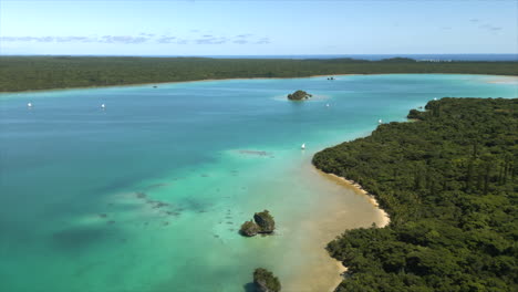 traditional pirogue outrigger canoes with sails transport tourists across upi bay, isle of pines - aerial flyover