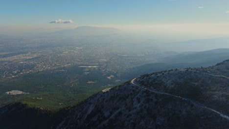 Geschwungene-Bergstraße-Mit-Der-Stadt-Athen-Im-Hintergrund---Parnitha