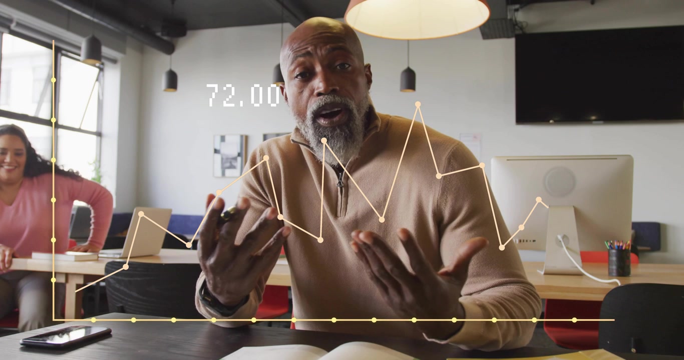 Presenter tapping stylus demonstrating sales data via floating graphs while coworker circling desk