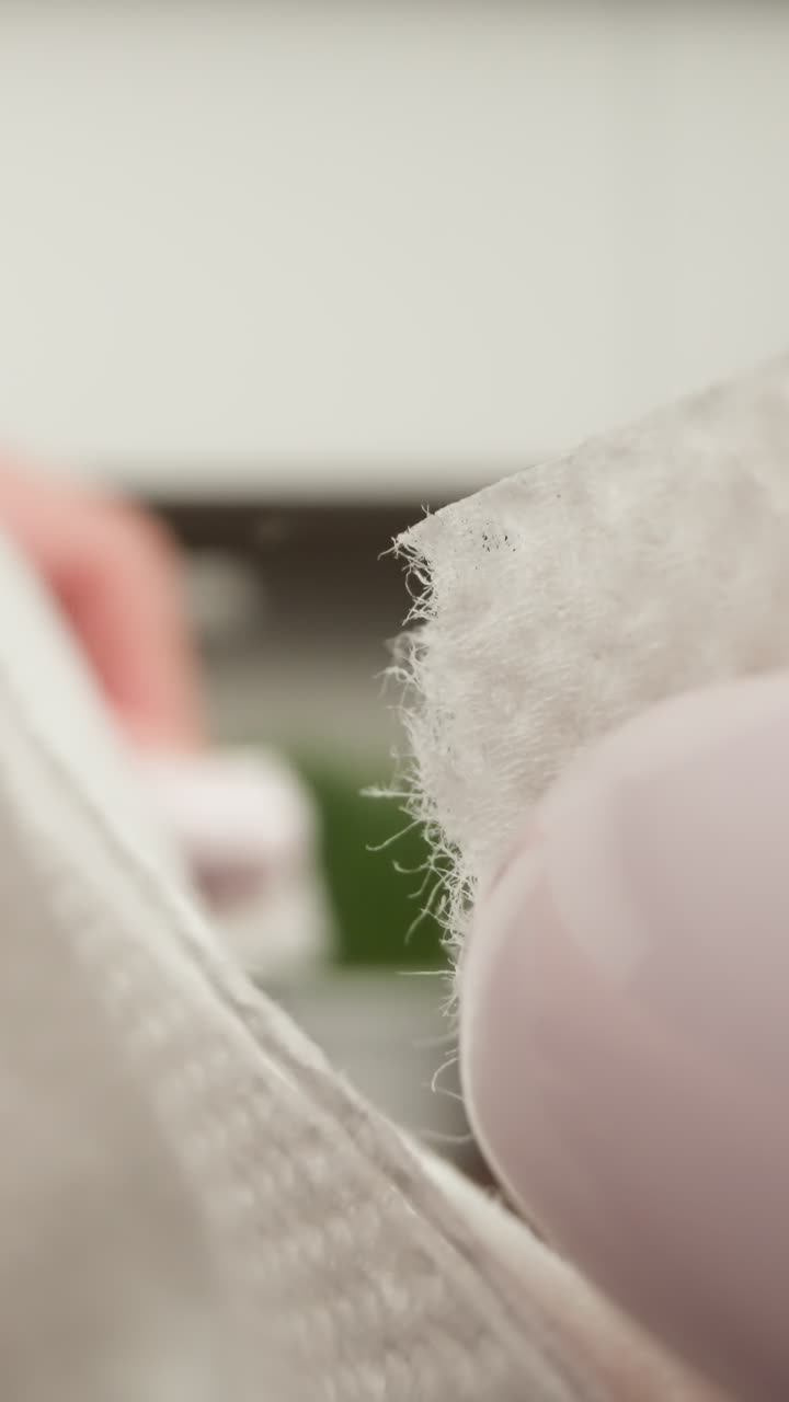 흐릿한 배경으로 색 접착제 붕대를 벗겨내는 손가락의 클로즈업