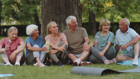 female fitness coach and elderly people chatting in park