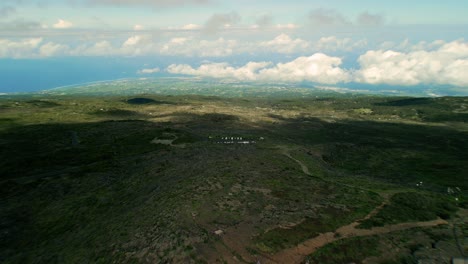 Drone-flying-fast-over-Crater-Wall-in-Mafate-La-Reunion-with-view-on-Ocean-and-small-cars-high-above-the-clouds