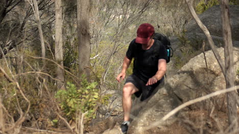 man climbs up rugged track at the you yangs national park, victoria australia