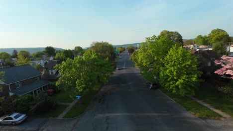 Charming-city-scene-in-America-with-car-in-road-during-sunset-time-in-the-evening