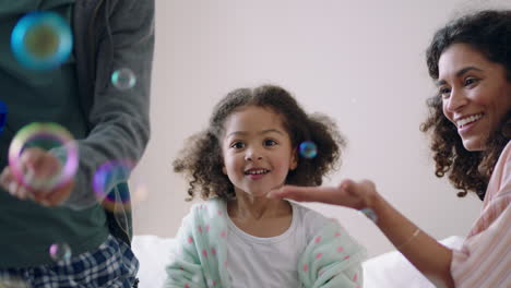 niña linda jugando con burbujas de jabón en casa madre y padre divirtiéndose con el niño en casa disfrutando del tiempo en familia el fin de semana