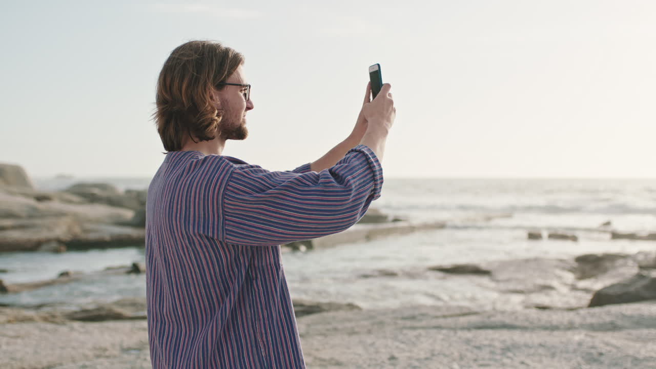 Uomo, smartphone e fotografia della spiaggia