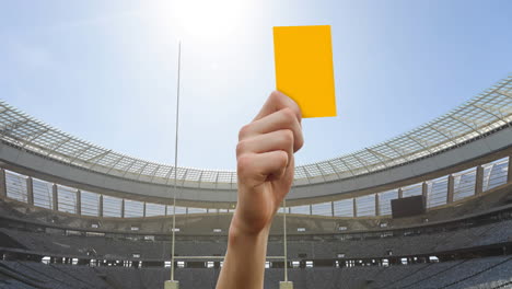 animation of referee holding yellow card on rugby pitch in sports stadium