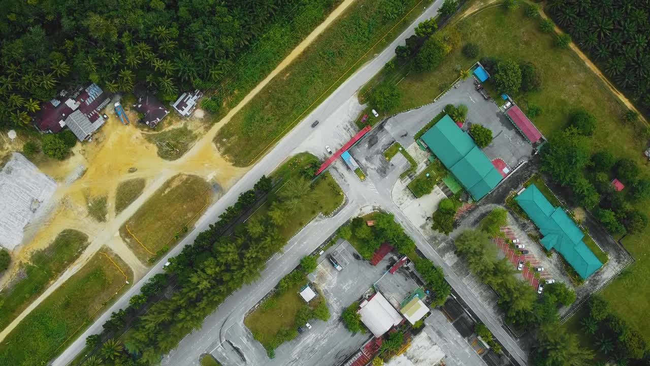 야자유 공장 폐수 거주지의 영화적 드론 영상은 인도네시아에 있는 야자나무 삼림 벌채로 둘러싸인 건물, 주택, 주요 도로 및 인프라로 구성되어 있습니다.