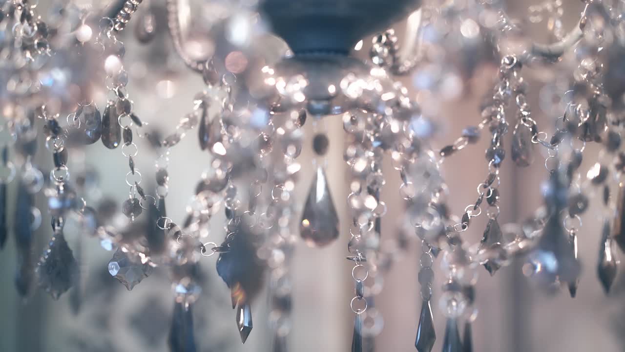 красивая люстра, с прозрачными подвесками и горящими лампами, мерцающим светом