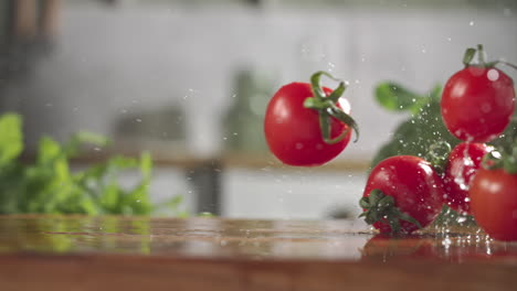 slow motion of red cherry tomatos falling on wet wooden board in a kitchen