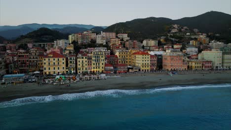 Beachfront-Italian-town-of-Varazze-and-city-life-at-sunset,-Aerial-drone-approach