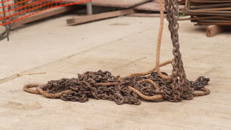 cadena de elevación y cuerda en el suelo levantadas por una grúa en el lugar de trabajo