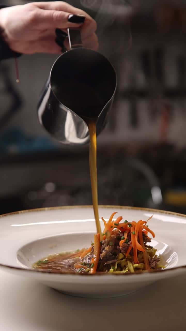 Chef Pouring Hot Broth into a Gourmet Soup Dish