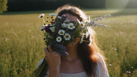 woman holding a bouquet of wildflowers in a sunlit field