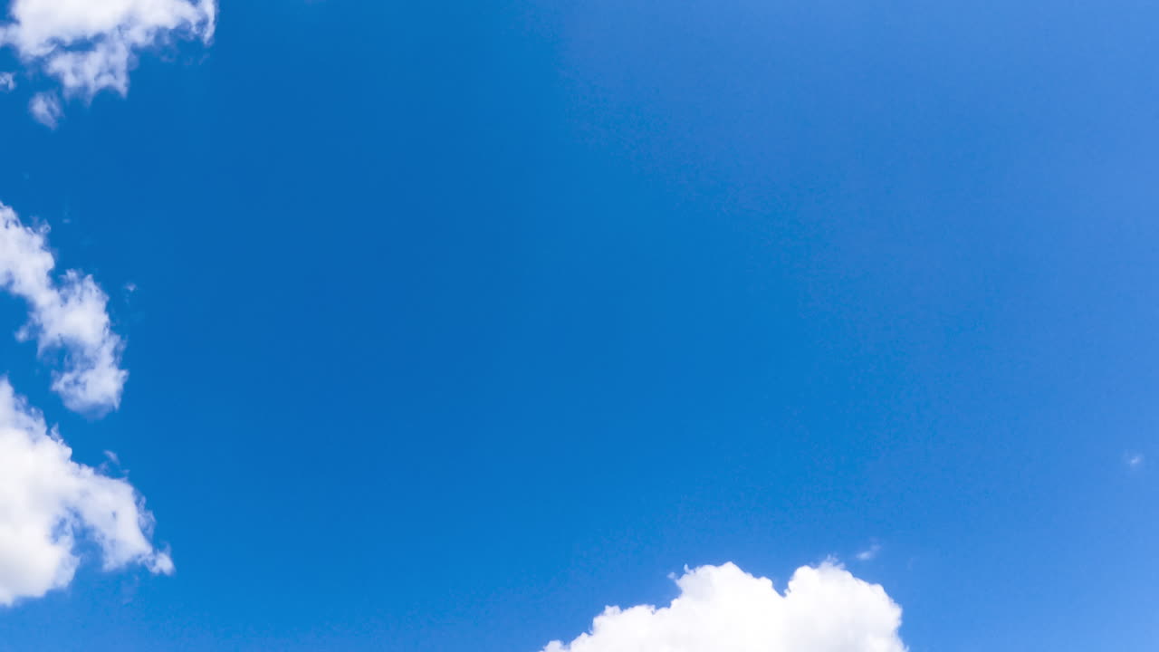 Adorable blue summer sky with soft little white clouds. Sunny day horizon from low angle view. Timelapse.