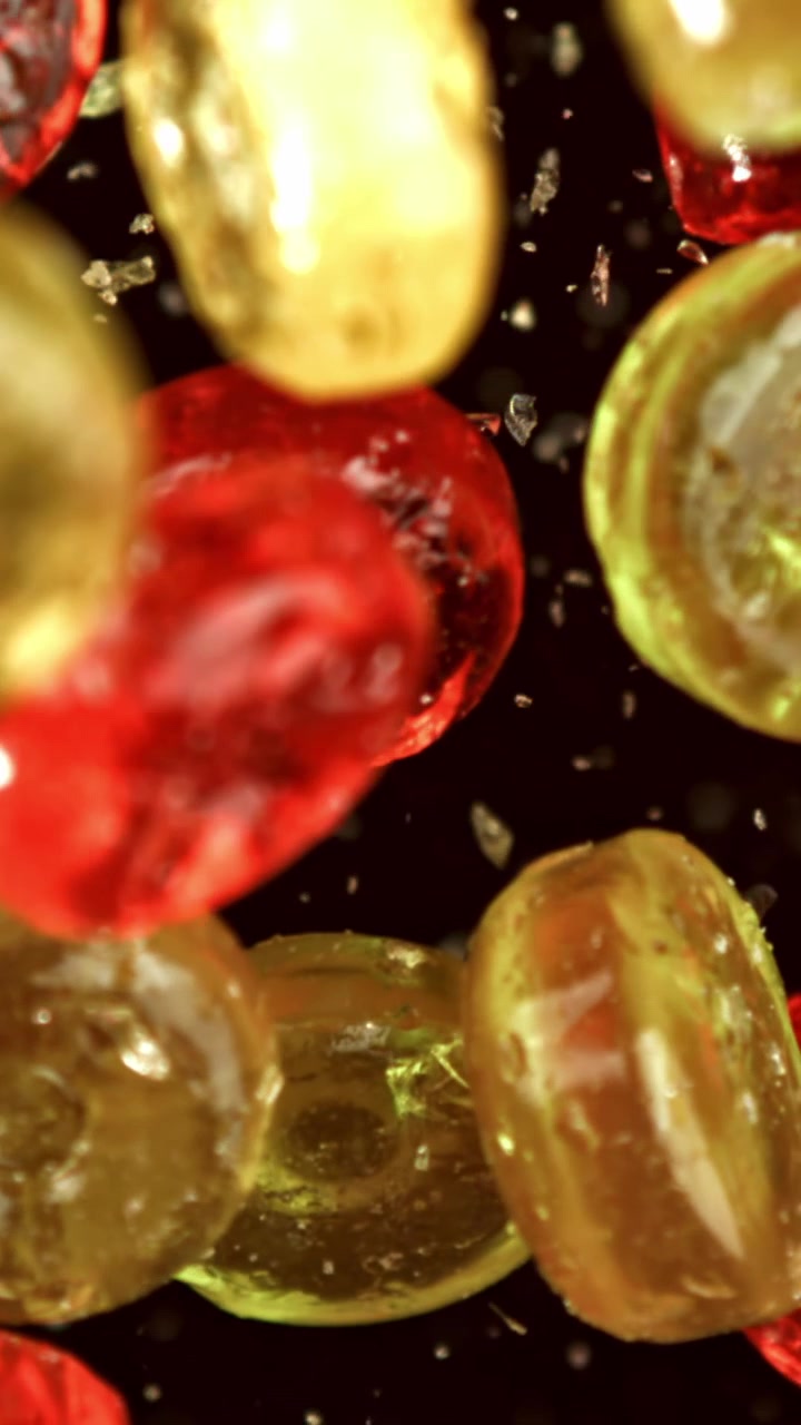 Vibrant Red and Yellow Candies Floating on Black Background