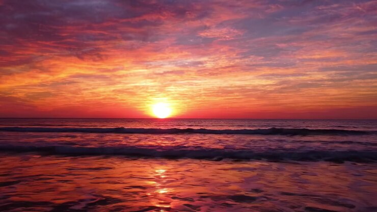 Breathtaking Sunset Over Tranquil Ocean Waves: A Serene Encounter with Nature's Vibrant Palette of Colors at Dusk