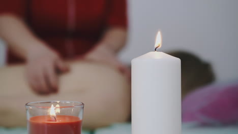 terapeuta de uniforme brilhante faz massagem a mulher no salão