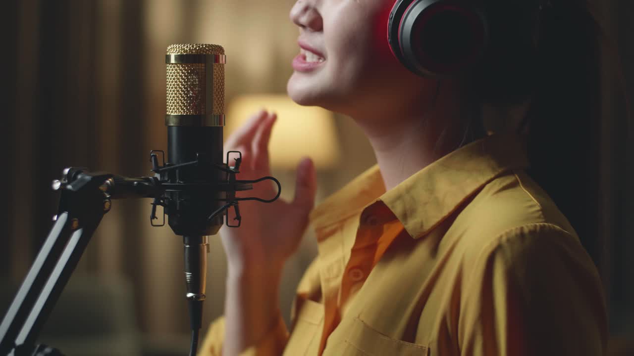 Primo piano di giovane donna asiatica che canta in uno studio di registrazione