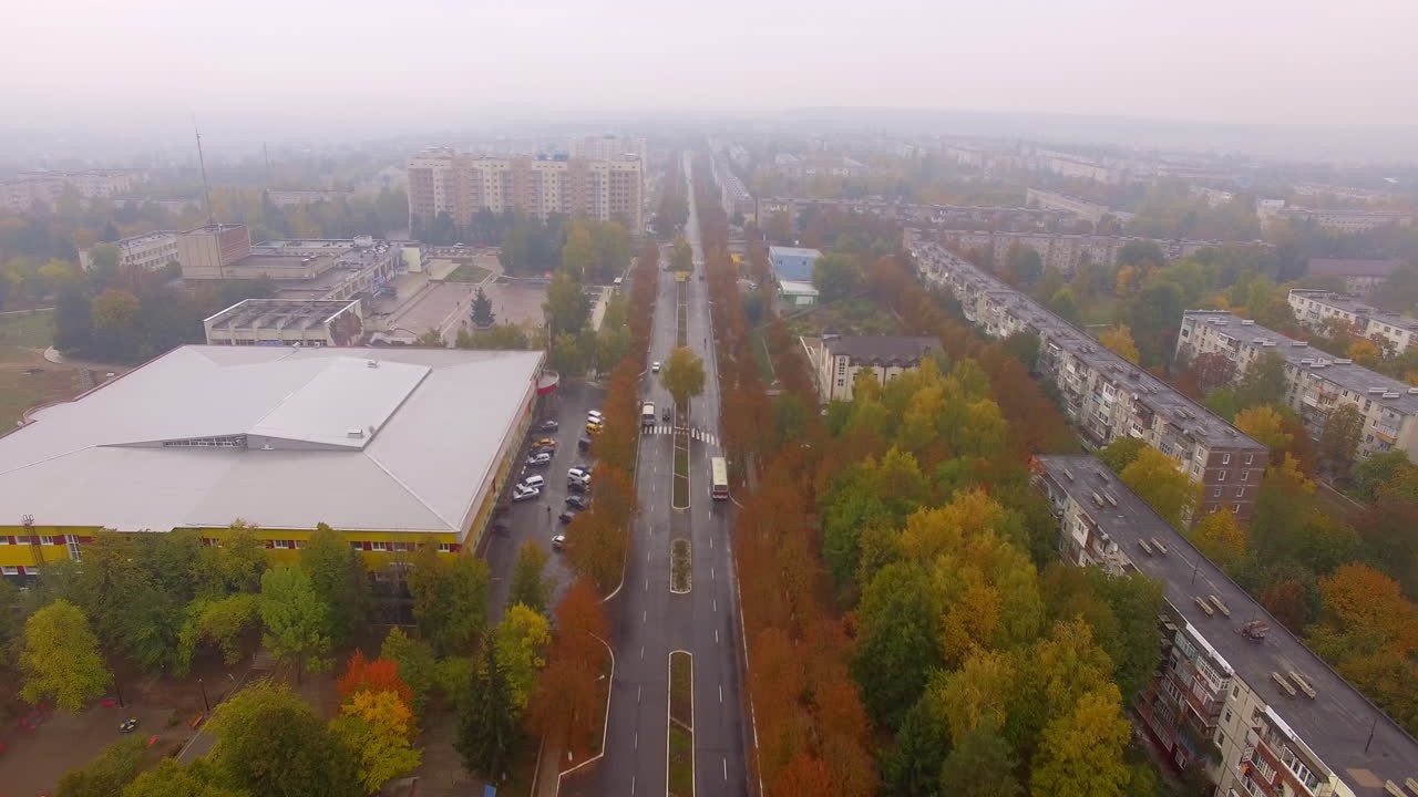 Two parallel straight roads crossing the city. Drone footage over the motorway up to a crossroads. Autumn city background.