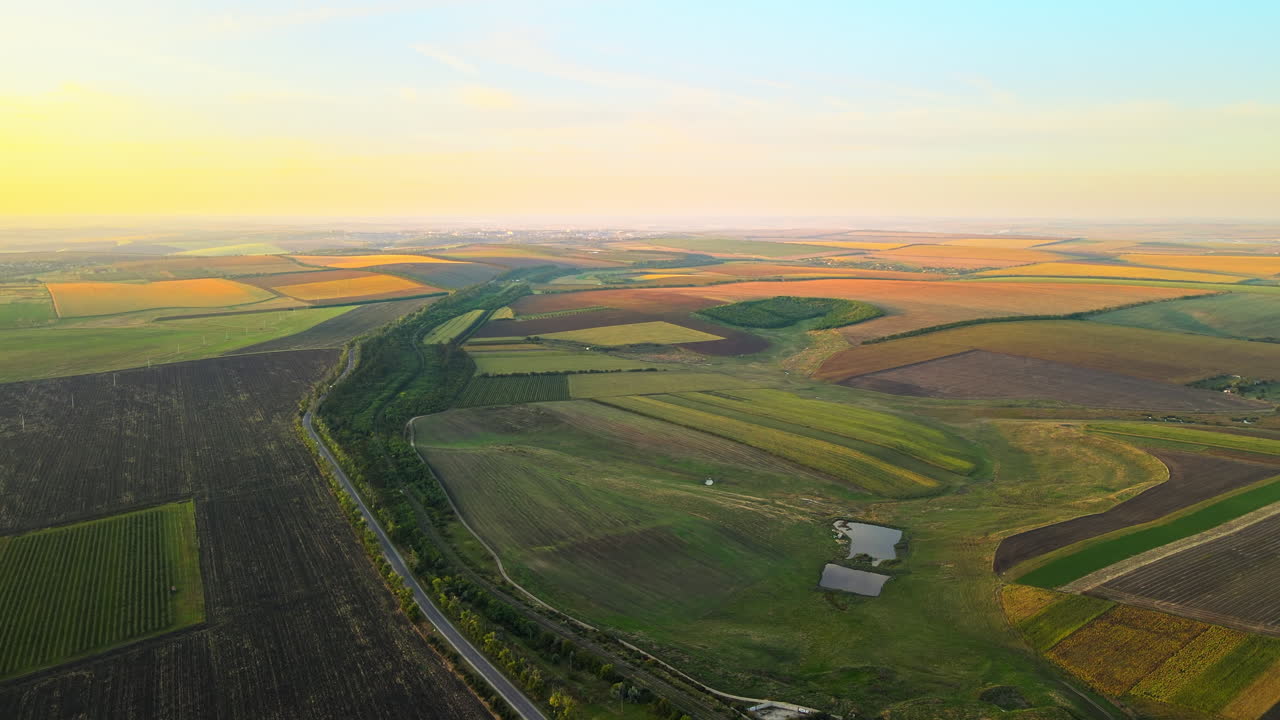 Aerial drone view of nature in Moldova at sunset. Wide fields, hills, road and village in the distance