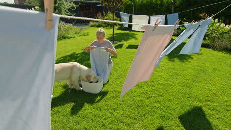 woman and dog doing laundry in the backyard