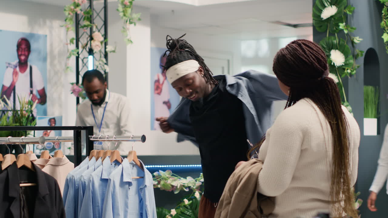 hombre en una boutique de moda se prueba ropa