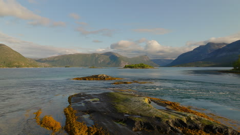 picturesque natural landscape of high tide flowing over the rock in efjorden, norway