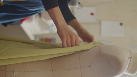 woman draping fabric on dress form in sewing studio