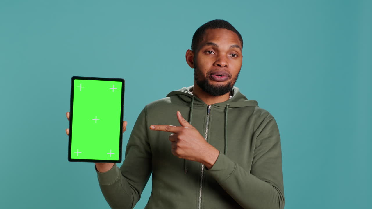 Upbeat person pointing towards chroma key device, giving positive feedback