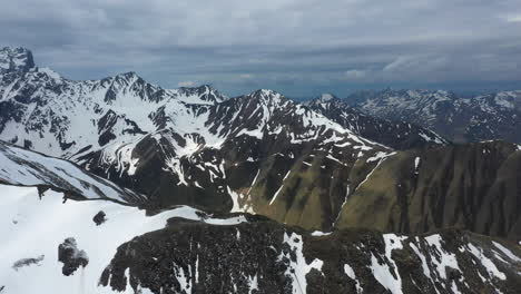 Rotating-cinematic-breathtaking-drone-shot-of-the-snow-covered-Georgian-Dolomites-in-the-Caucasus-mountains-in-Georgia