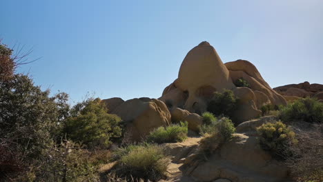 the amazing skull rock formation at joshua tree national park in california under the clear blue sky - panning shot