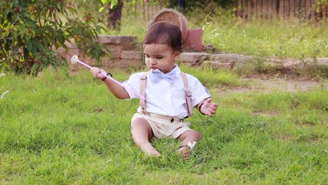 isolated-cute-baby-boy-toddler-in-white-cloth-playing-at-park-from-flat-angle