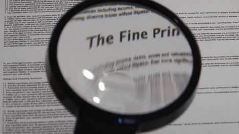 magnifying glass passes over paper to reveal the words the fine print