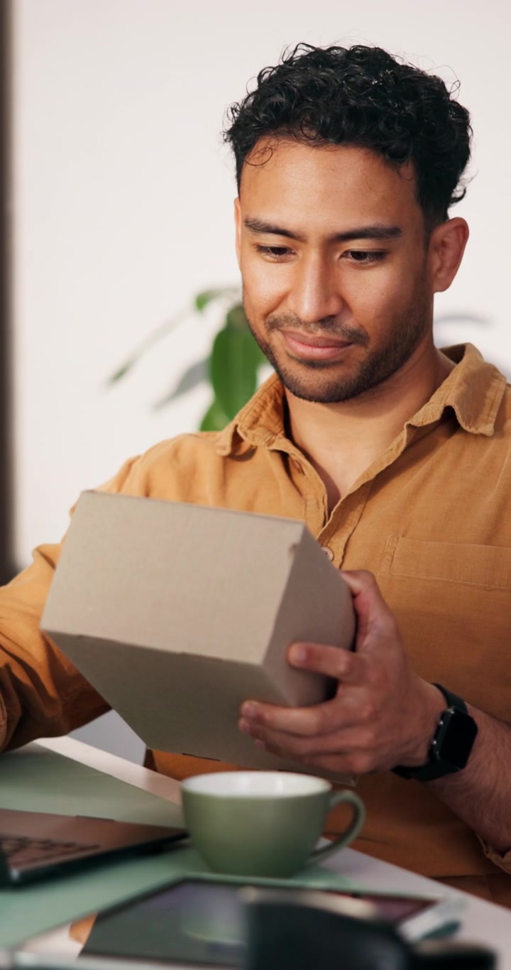 Man Inspecting and Packing Cardboard Box in Office