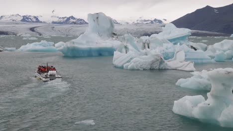 laguna glaciar en islandia con dos barcos turísticos cabalgando por el agua