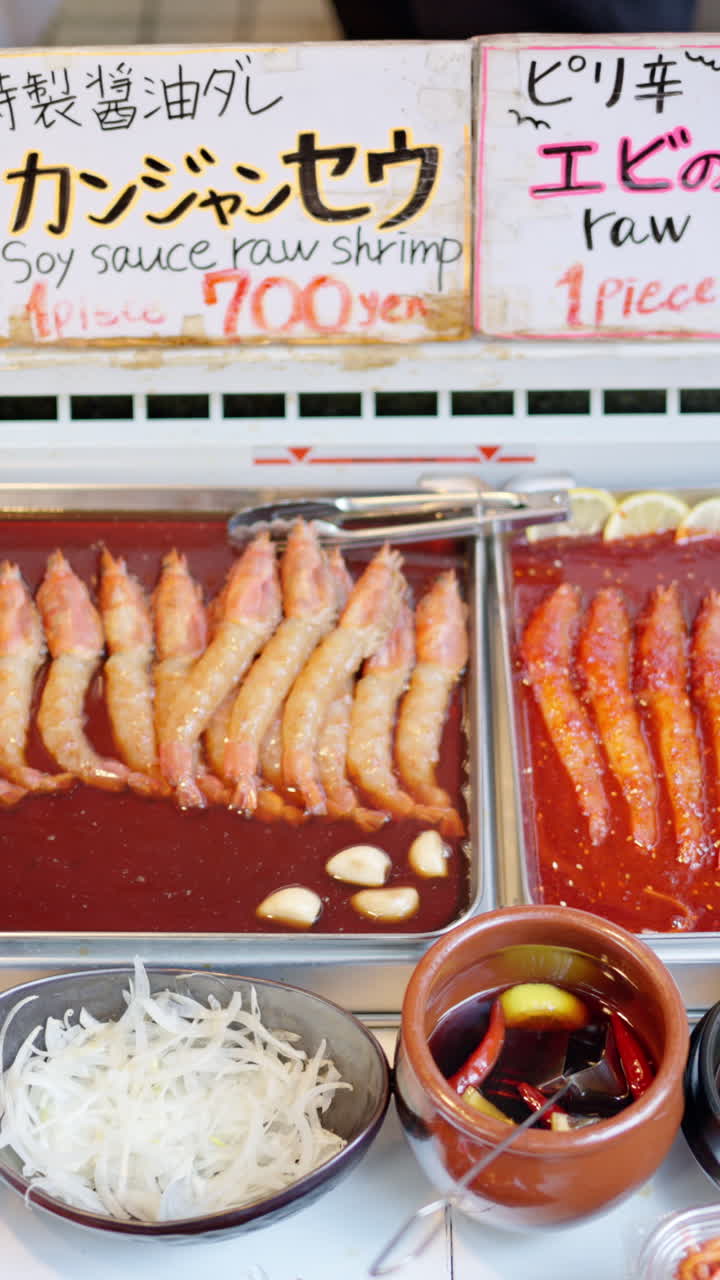 Close up of seafood in red sauce at the Tsukiji Fish Market in Japan. Vertical
