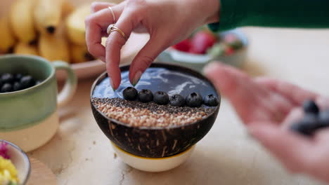 woman, hand and blueberry bowl in diet