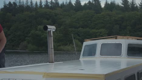 Timelapse-young-man-painting-white-paint-roof-of-wooden-boat