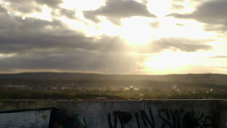 timelapse of sunstreaks moving over a landscape with graffity on a wall