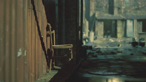 abandoned alley with a wooden chair foreground during daylight hours