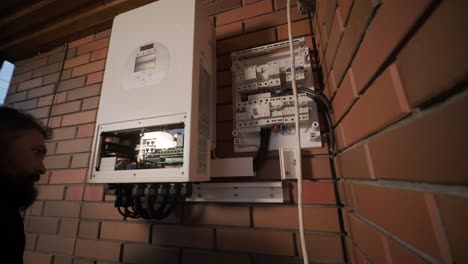 an electrician installing an inverter in a home. the image shows technical skill, modern tools, and attention to safety in electrical work