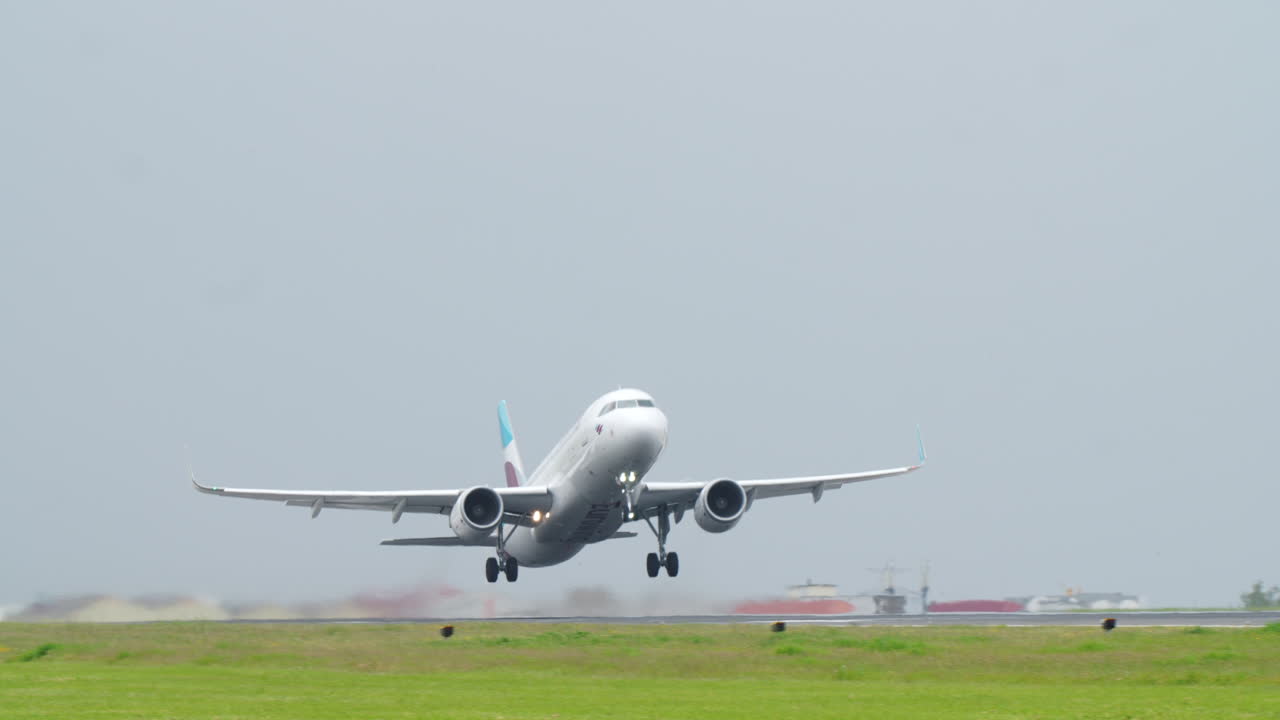 LISBON, PORTUGAL - APRIL 7, 2025: Frontal view of a Eurowings Airbus A320 aircraft taking off from Lisbon Airport. The airplane is captured mid-air just after liftoff, with landing gear extended and both engines visible