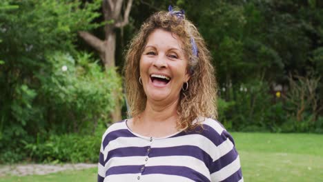 Animation-of-biracial-senior-woman-smiling-at-camera-in-garden