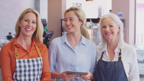 retrato del propietario femenino y el personal que trabaja en una cafetería o restaurante con tableta digital