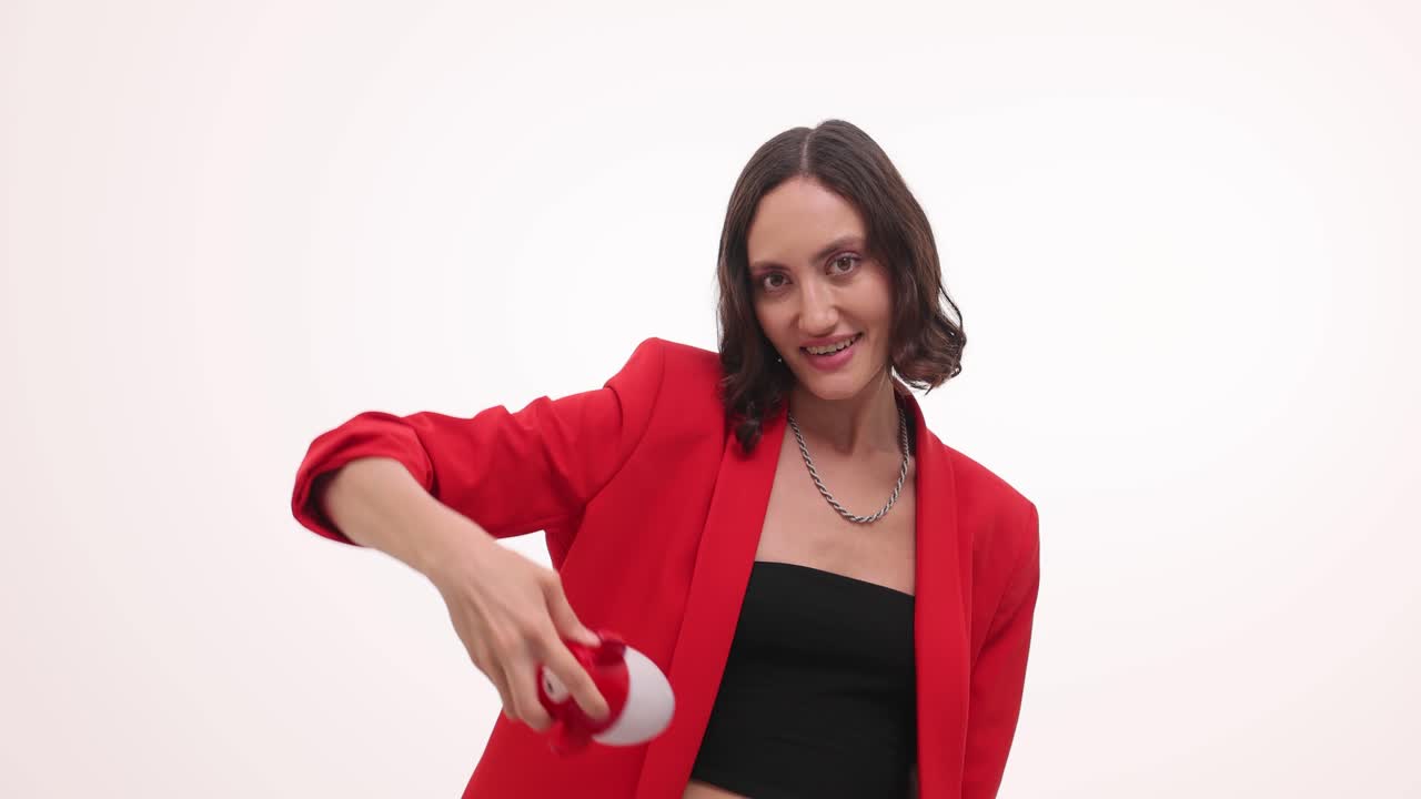 A woman in a red blazer holds a rocket toy and points, symbolizing ideas or business launch