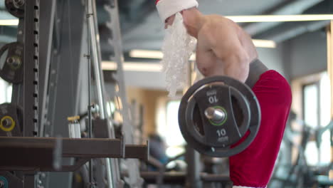 hombre de fitness activo haciendo peso muerto en el gimnasio. hombre disfrazado de santa haciendo ejercicio