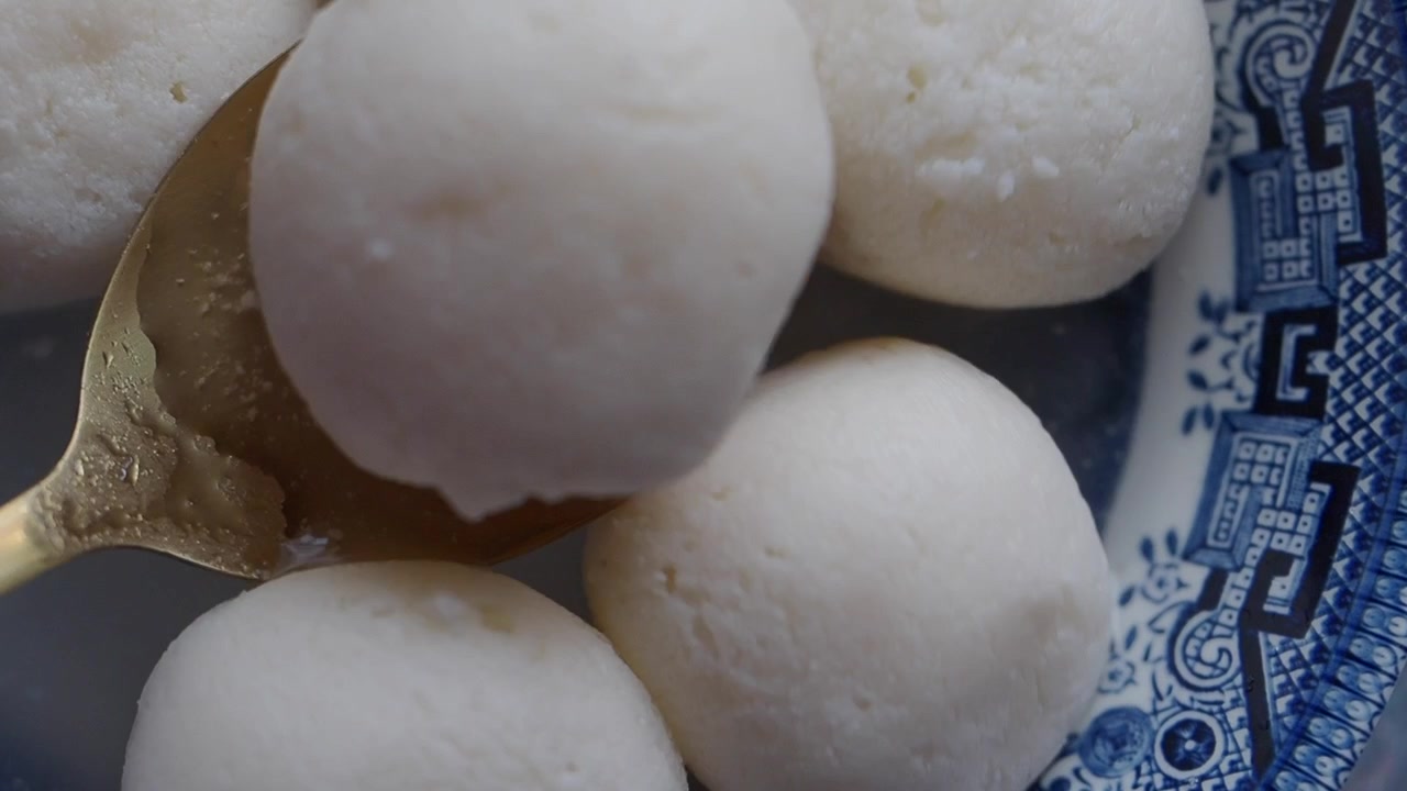 Close-up of Rasgulla Being Lifted from a Bowl