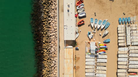 Toma-De-Arriba-Hacia-Abajo-Con-Drones-Que-Captura-Una-Playa-Llena-De-Barcos-Junto-Al-Mar-Verde